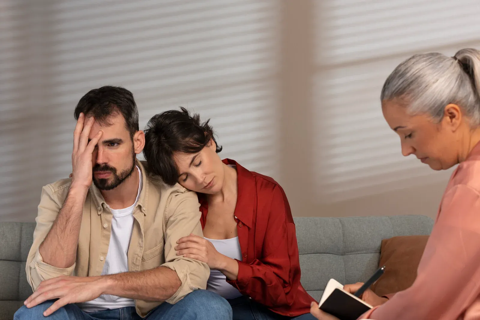 mulher abraça e conforta homem ao que parece ser um momento dificil 